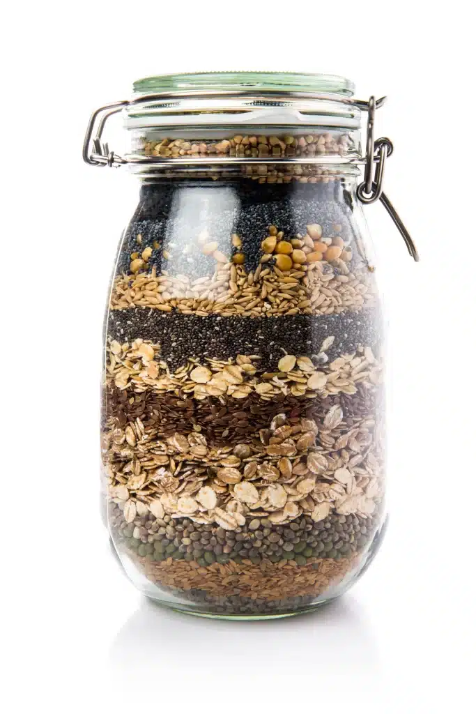 Ideia de upcycling: reutilizando frasco de vidro como vaso decorativo com sementes naturais - projeto DIY sustentável.